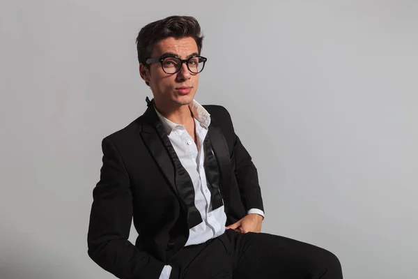 Hombre elegante con corbata deshecha y gafas sentado — Foto de Stock