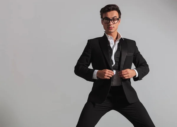 Elegant man wearing glasses unbuttoning his tuxedo — Stock Photo, Image