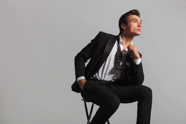 Jovem homem de smoking e desfeito bowtie sonhando — Fotografia de Stock