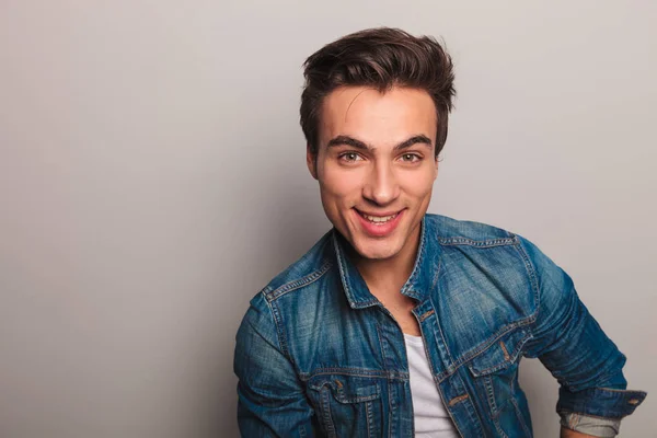 Närbild porträtt av en leende ung man i jeansjacka — Stockfoto