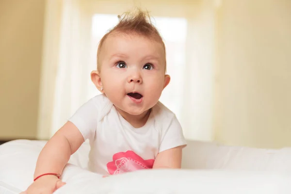 Bonito bebê menina está fazendo um engraçado rosto — Fotografia de Stock