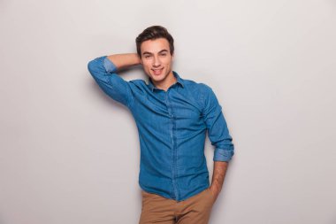 gülümseyen adam eliyle başının arkasında kamera için poz 