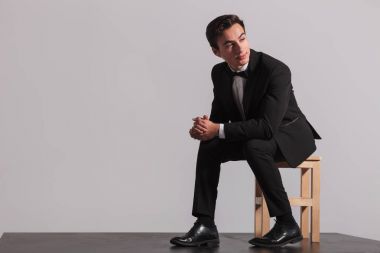 Smokin ve avuç içi bir arada tutan papyon oturan adam 