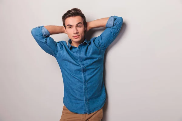 Serious casual man posing with both hands behind neck — Stock Photo, Image