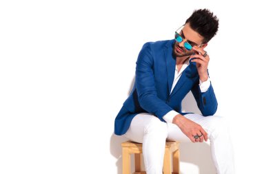 güneş gözlüğü alarak bir oturmuş moda adamın yan resmi 