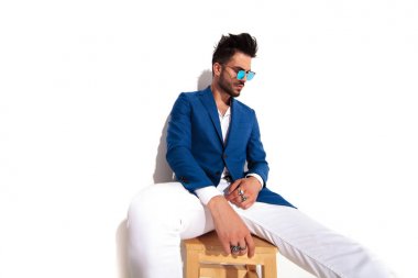 şık erkek yüzük parmakları ve güneş gözlüğü takan oturmuş