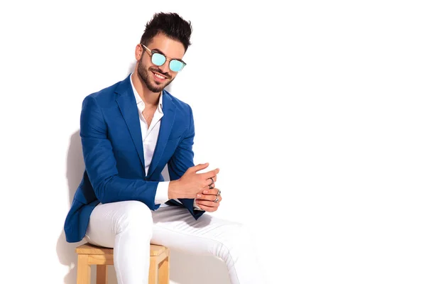 Glücklicher eleganter Mann mit Sonnenbrille und lacht im Sitzen — Stockfoto