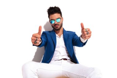 ciddi moda adam oturuyor ve yapar ok işareti