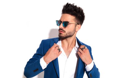 tasmasını tutan güneş gözlüklü genç seksi adam closeup