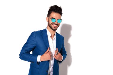 tasmasını tutan güneş gözlüğü içinde zarif genç adam gülüyor