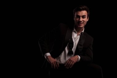 smokin içinde oturan adam gülüyor