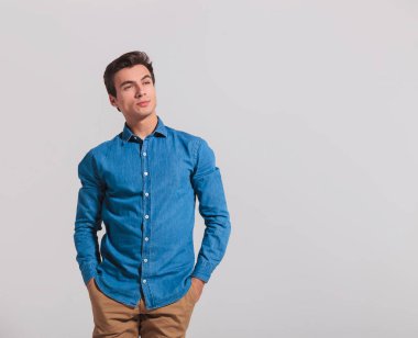 Elleri ceplerinde rahat genç adam uzakta görünüyor