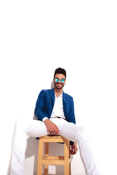 Mode eleganta mannen skrattar medan du sitter på stol — Stockfoto
