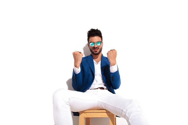 Serious elegant man sitting and showing his fists — Stock Photo, Image