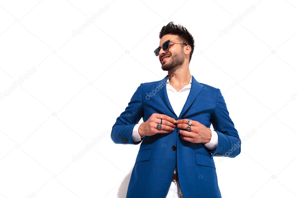 elegant man buttoning his coat and laughs 