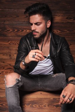 güneş gözlüklerini tutan deri ceketli adamı