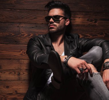 çapraz ayaklı oturan moda adam resmini yan