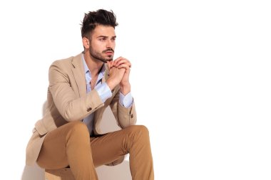 dua ederken oturma oturmuş bir işadamı yan görünüm 