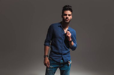 genç adam dururken yakasını tutarak