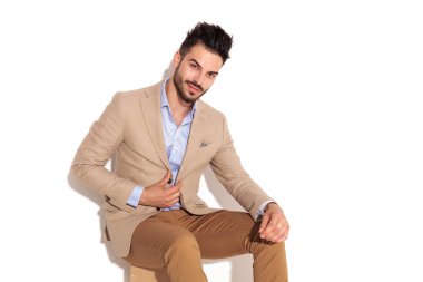 Ceketini oturma sırasında kapanış gülümseyen genç işadamı 