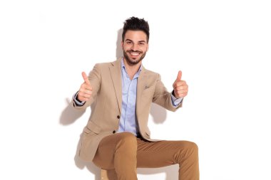 ok işareti yapmak iş adamı oturmuş gülüyor