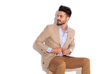 mutlu oturan işadamı kat kadar düğmelerini ve yan görünüyor