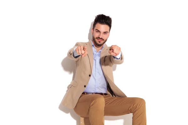 Glücklich sitzender Geschäftsmann, der mit dem Finger zeigt — Stockfoto