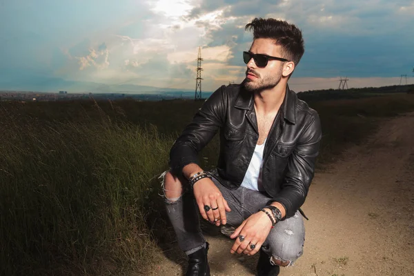 Hombre en chaqueta de cuero y gafas de sol celebración de cigarrillo — Foto de Stock