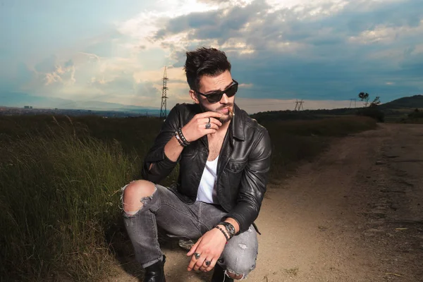 deri ceket ve güneş gözlüğü genç adam sigara içiyor 