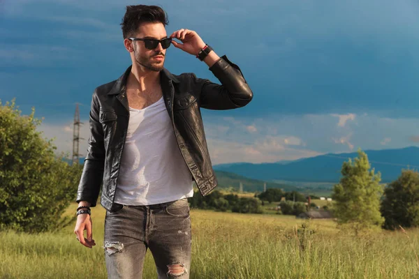 moda üzerinde güneş gözlüklerini koyarak deri ceketli adamı
