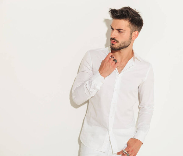 fashion man dressed in white fixing his collar 