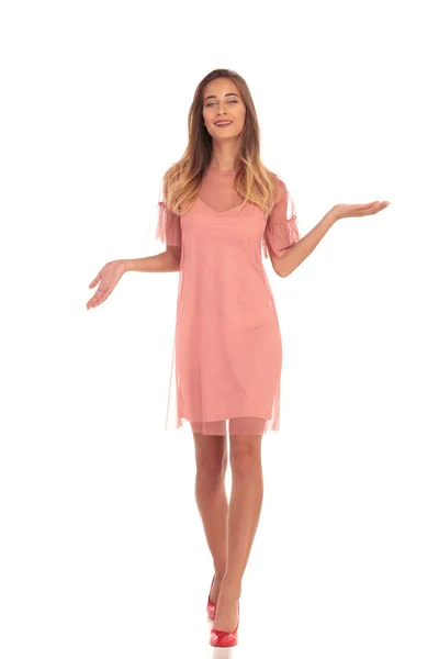 Lachende vrouw in jurk lopen en u te verwelkomen — Stockfoto