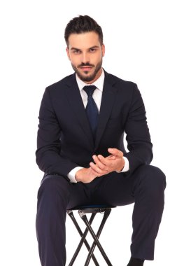 genç iş adamı gülümseyerek oturan ve avuç içi bir arada tutan