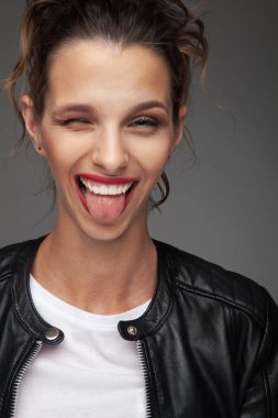 genç kadın dilini çıkarmış göz kırpıyor gülüyor