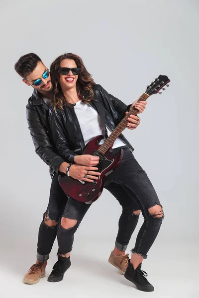 Laughing woman plays electric guitar with her man — Stock Photo, Image