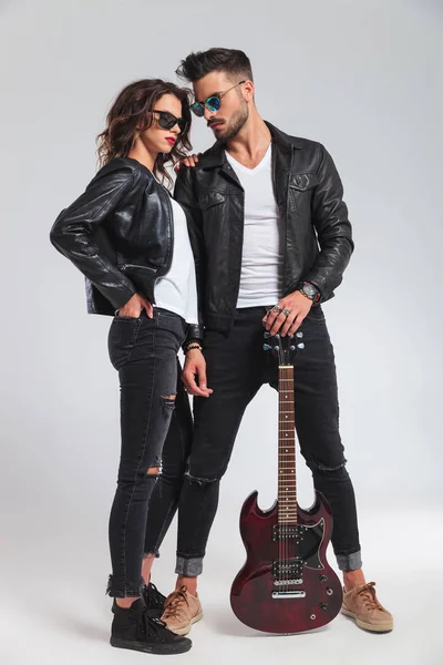 Homem olha para sua mulher enquanto segurando guitarra elétrica — Fotografia de Stock