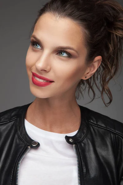 Smiling young woman looks up to a side — Stock Photo, Image