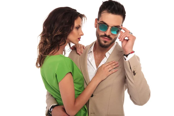 Sexy man fixing sunglasses while embracing his woman — Stock Photo, Image