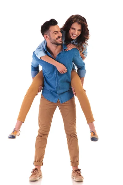 Happy man carrying woman on the back — Stock Photo, Image