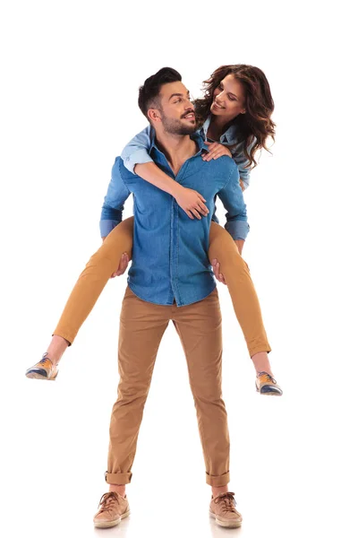 Paar schaut sich an, während Mann Frau trägt — Stockfoto