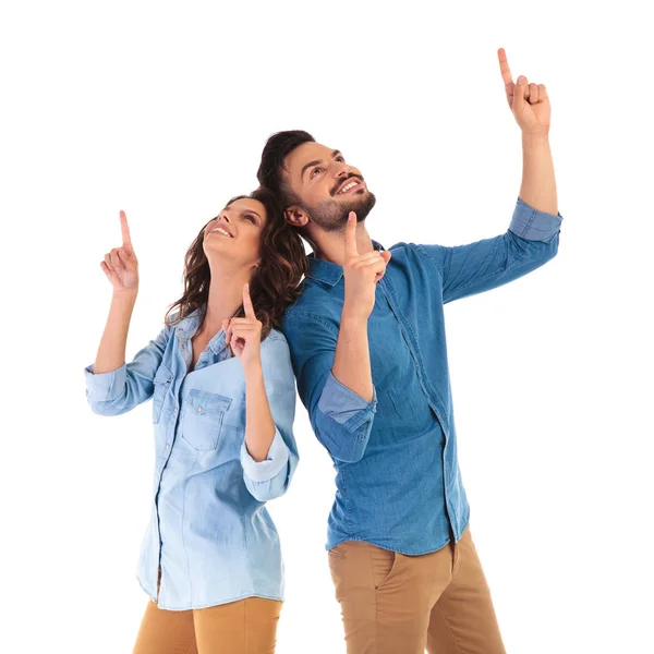 Happy casual couple pointing up — Stock Photo, Image