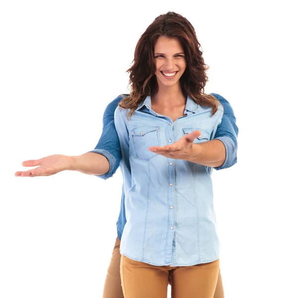 Smiling woman with man hiding behind her welcomes — Stock Photo, Image