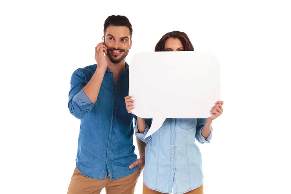 Frau hält Sprechblase, während Mann telefoniert — Stockfoto