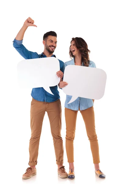 Laughing casual couple holding speech bubbles — Stock Photo, Image