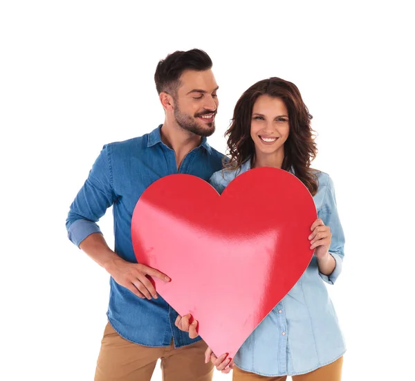 Pareja casual mostrando un gran corazón rojo —  Fotos de Stock