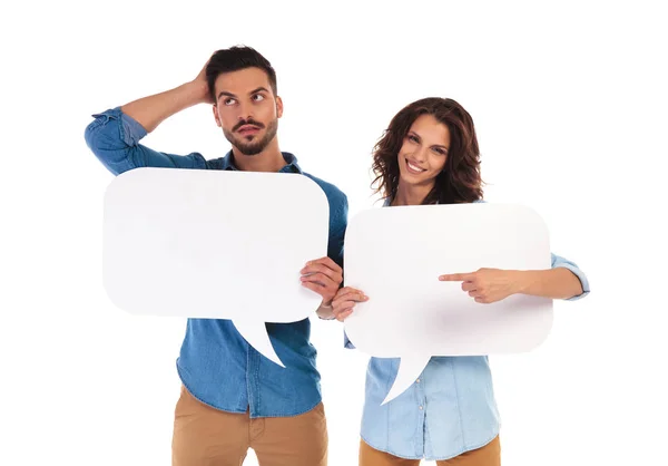Woman holding speech bubble points to thoughtful man — Stock Photo, Image