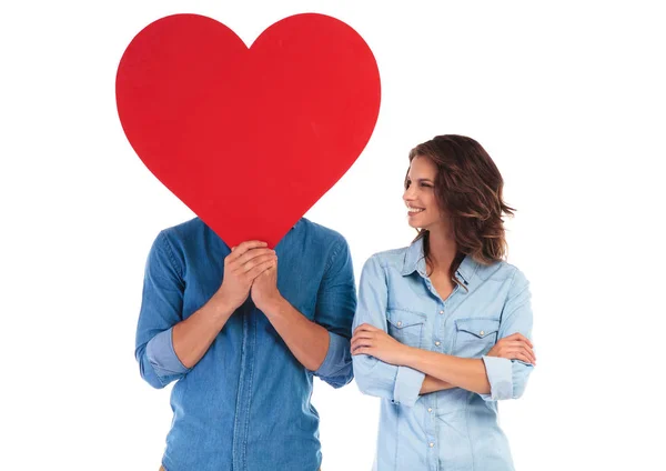 Kvinnan ser på sin älskare med hjärtat över hans ansikte — Stockfoto