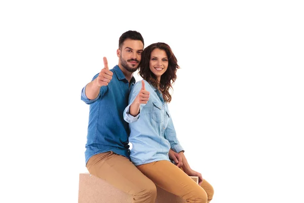 Seated casual couple making the ok sign — стоковое фото