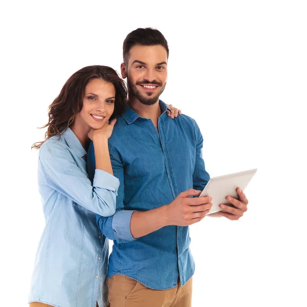 Sorrindo casal casual feliz com um computador tablet pad — Fotografia de Stock