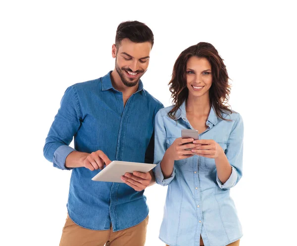 Casual young couple working on different mobile devices — Stock Photo, Image